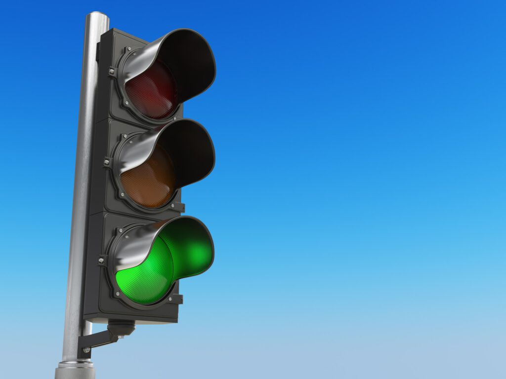 Traffic light with green color on blue sky background.
